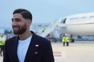 Pemain Timnas Iran tiba di bandara mengenakan jas gelap dengan sematan pin 168 di kerah jasnya untuk Piala Dunia 2026.